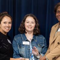Three women holding an award